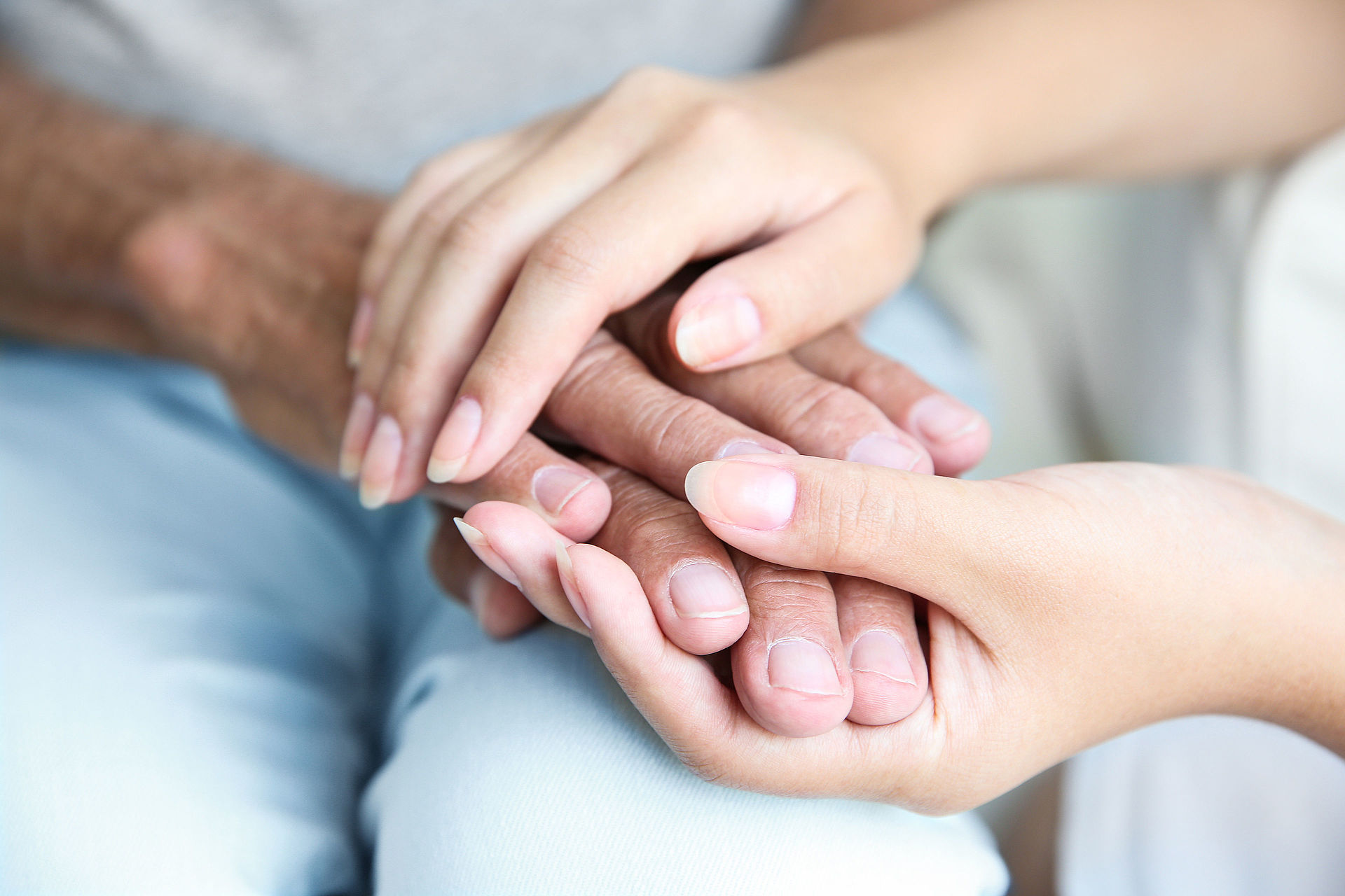 Eine jüngere Frau hält einer Älteren die Hände