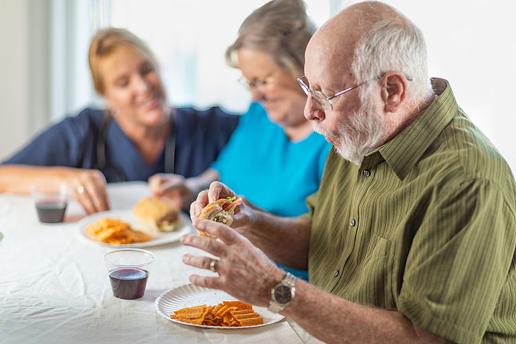 Seniorinnen und Senioren essen zusammen
