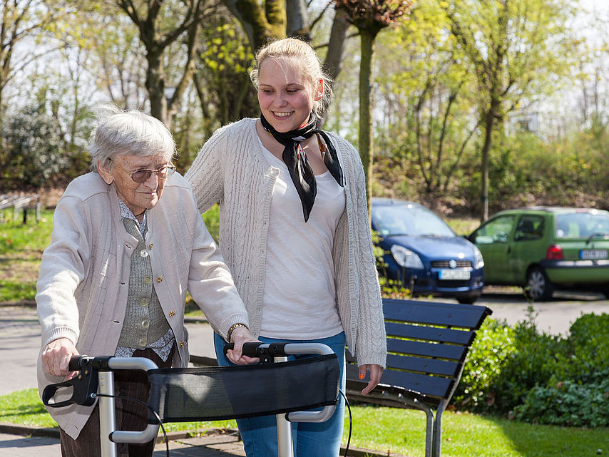 Freiwilligendienst Eine Freiwilligendienstleistende begleitet einen Seniorin beim Spaziergang