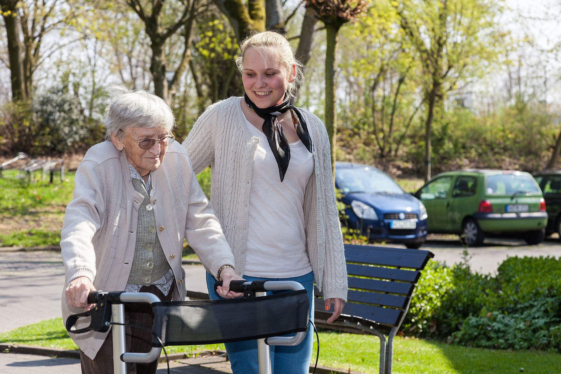 Eine Freiwilligendienstleistende begleitet einen Seniorin beim Spaziergang