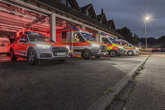 Hier stehen die Fahrzeuge des Rettungsdienstes vor der geöffneten Fahrzeughalle