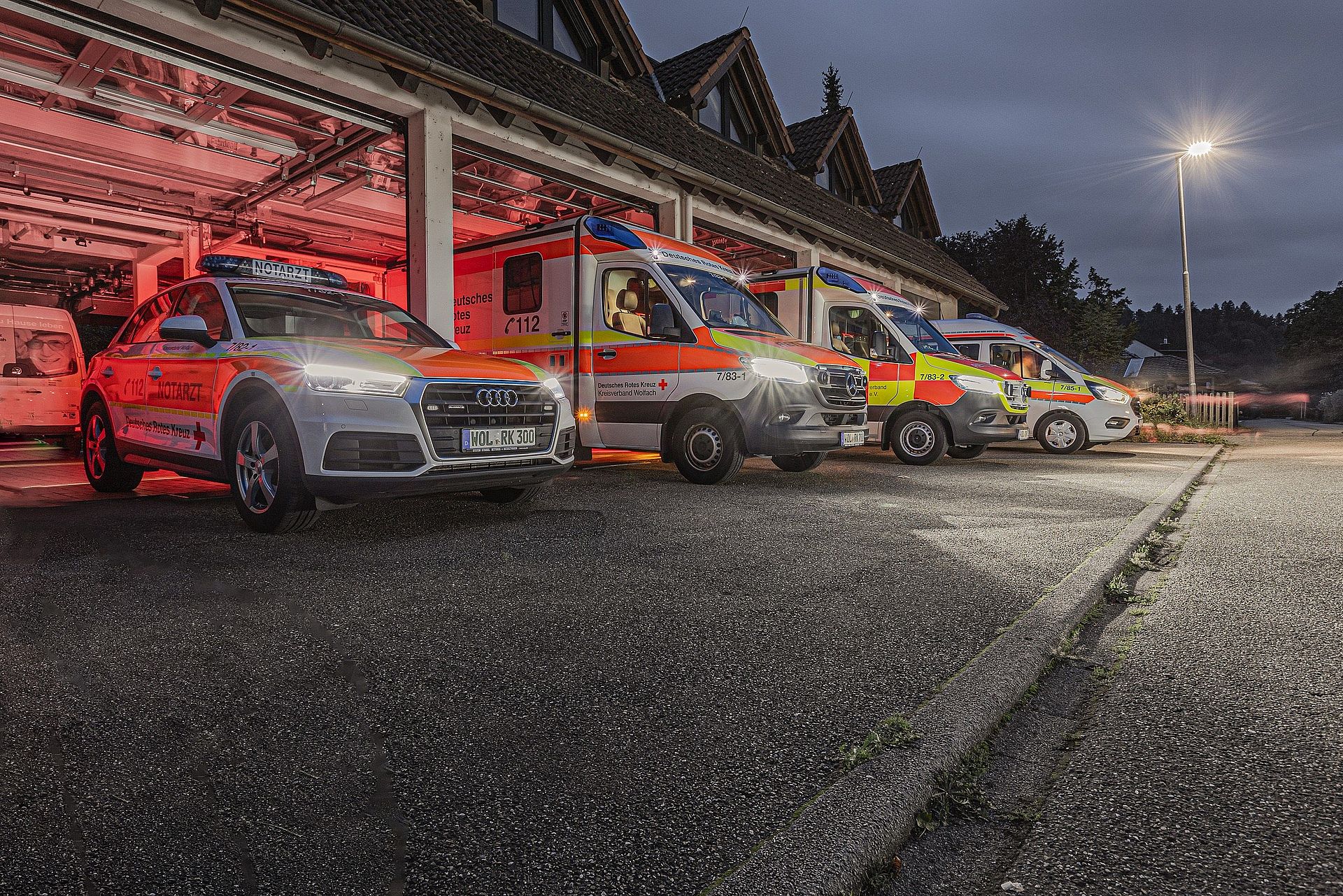 Hier stehen die Fahrzeuge des Rettungsdienstes vor der geöffneten Fahrzeughalle